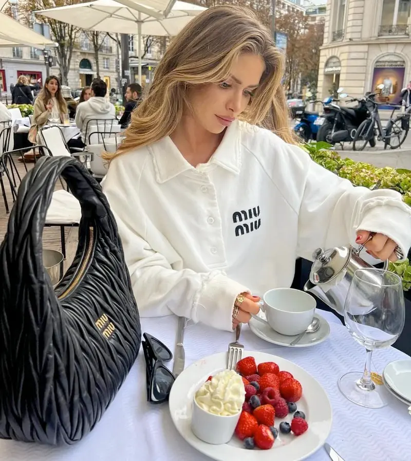 Luxury replica Miu Miu Wander Hobo bag styled on coffee table with accessories